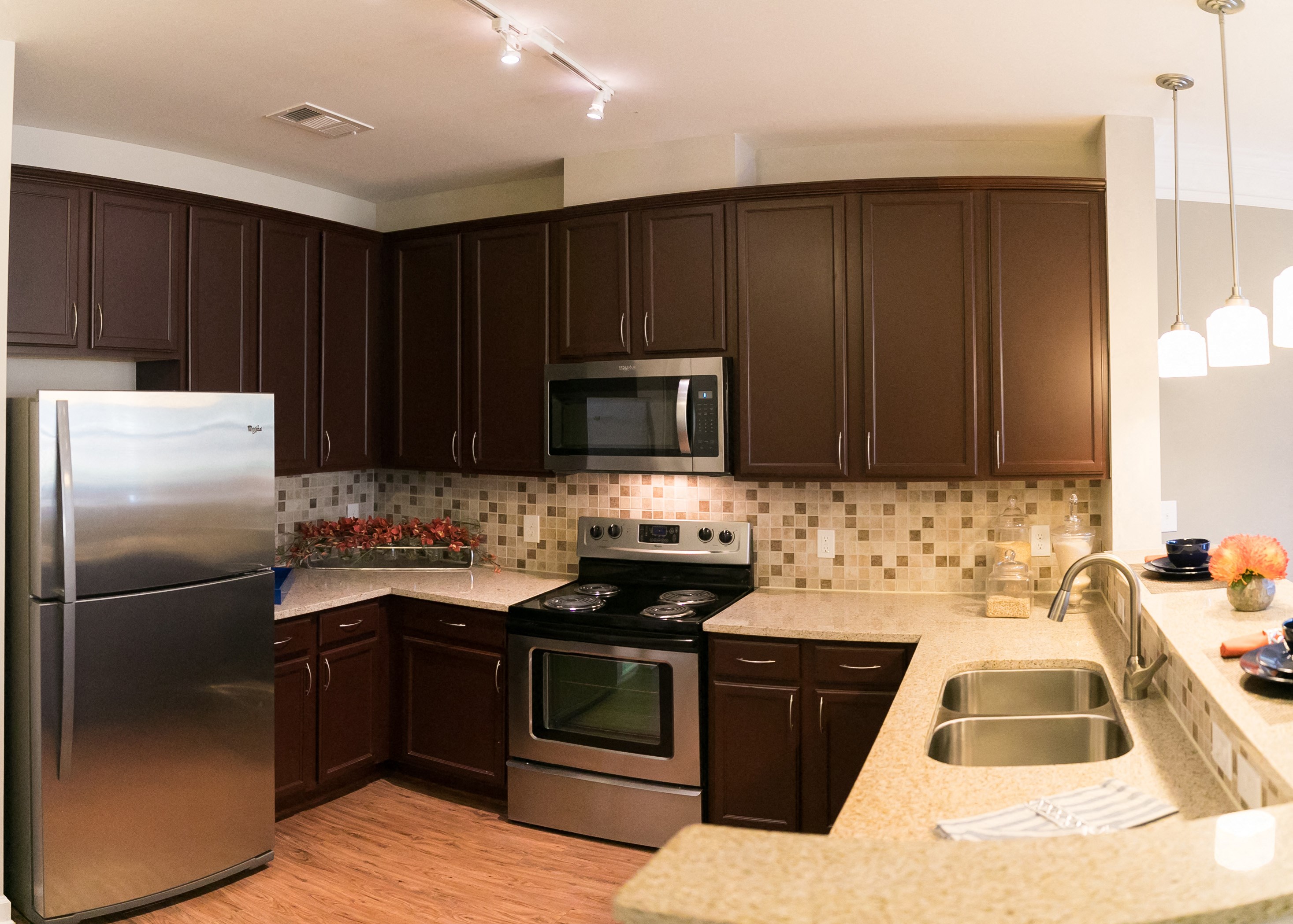 Kitchen area with brown cabinets, stainless steel appliances, and granite countertops.